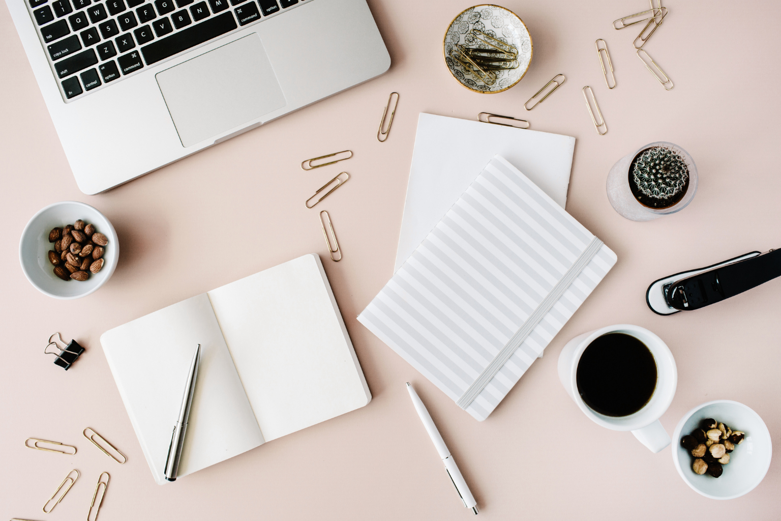 Heller Schreibtisch mit Laptop, Notizbuch, Kaffee und Arbeitsmaterialien – Symbol für bewusste Gestaltung im Job.